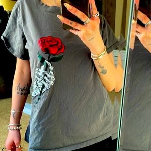 Gray T-shirt with skeleton hand holding a flower: a rose.